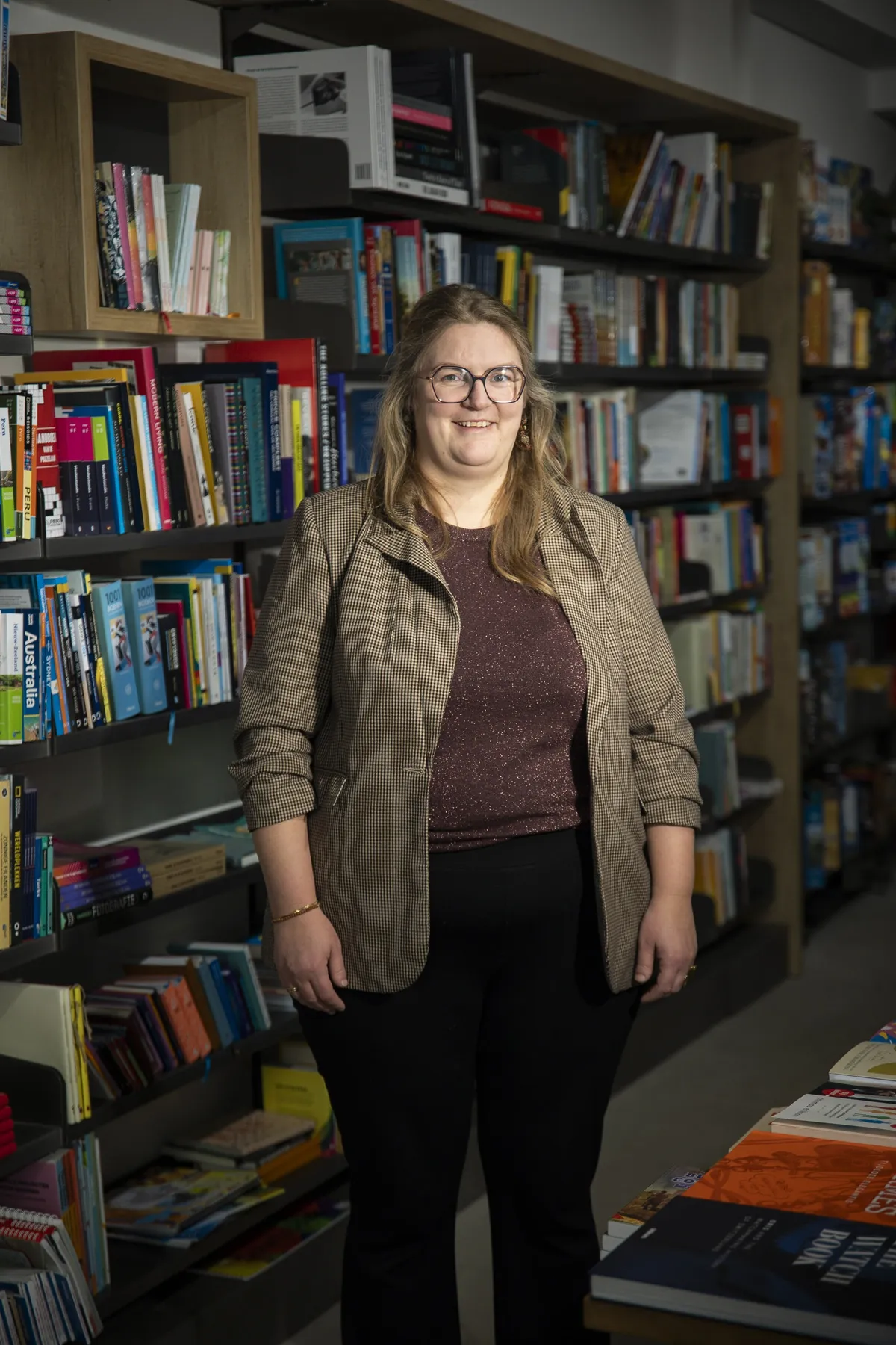 Portret van raadslid Aafke Ouwerkerk-Breedveld tussen boekenkasten
