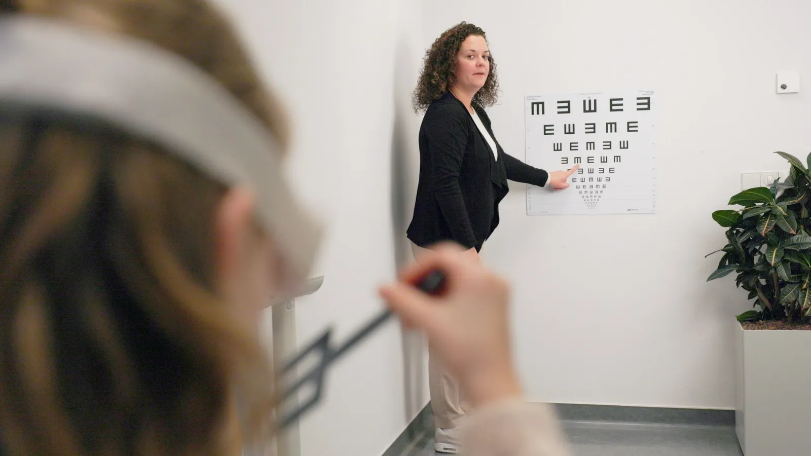 Jeugdarts voert een oogtest uit bij een kind met een letterkaart aan de muur, still uit de campagnevideo voor GGD West-Brabant