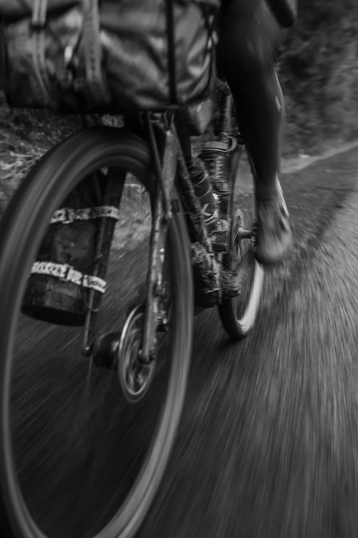 Wielrenner met bikepacking-tassen, close-up in zwart-wit