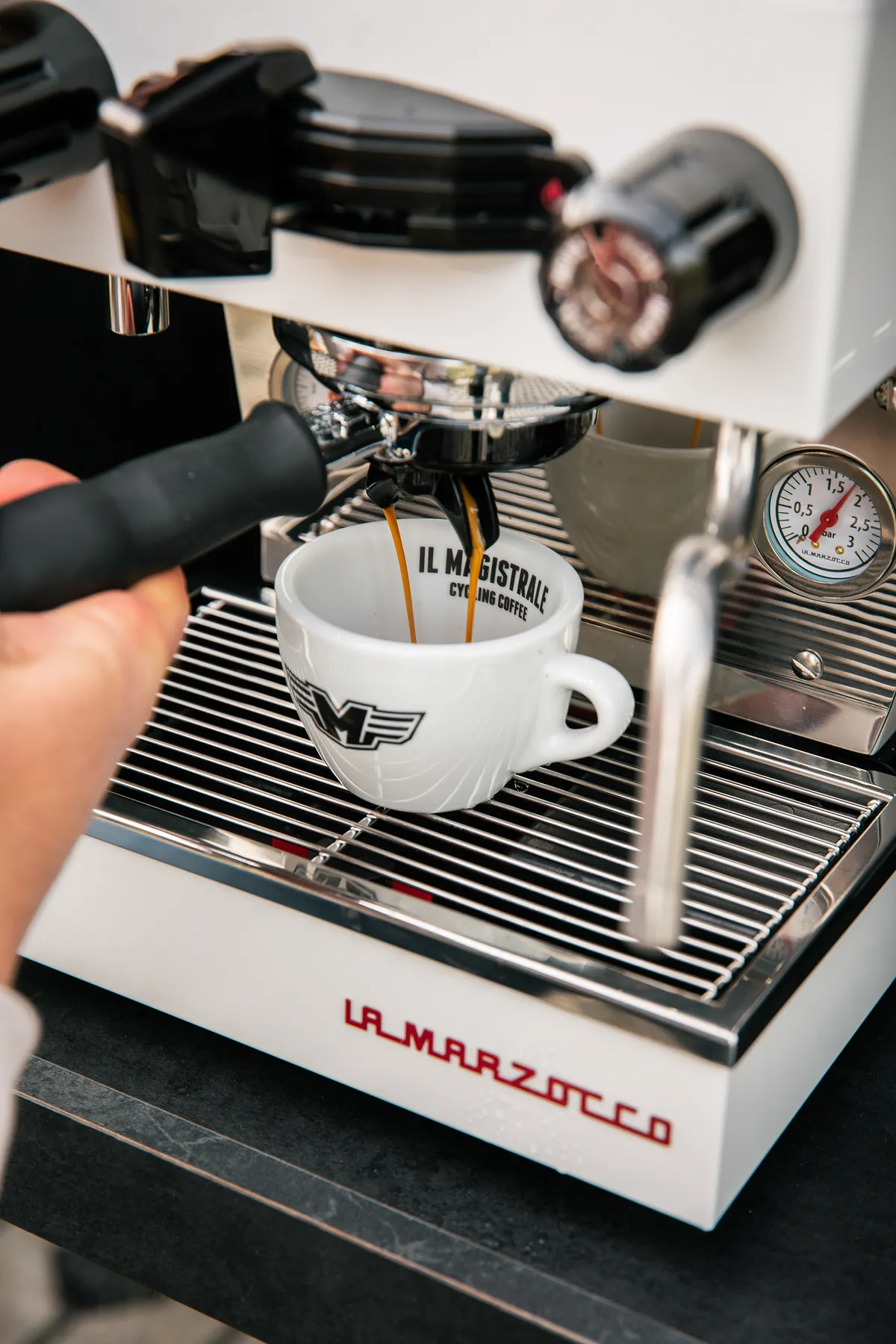 Espresso wordt geschonken in een kopje met het Il Magistrale-logo