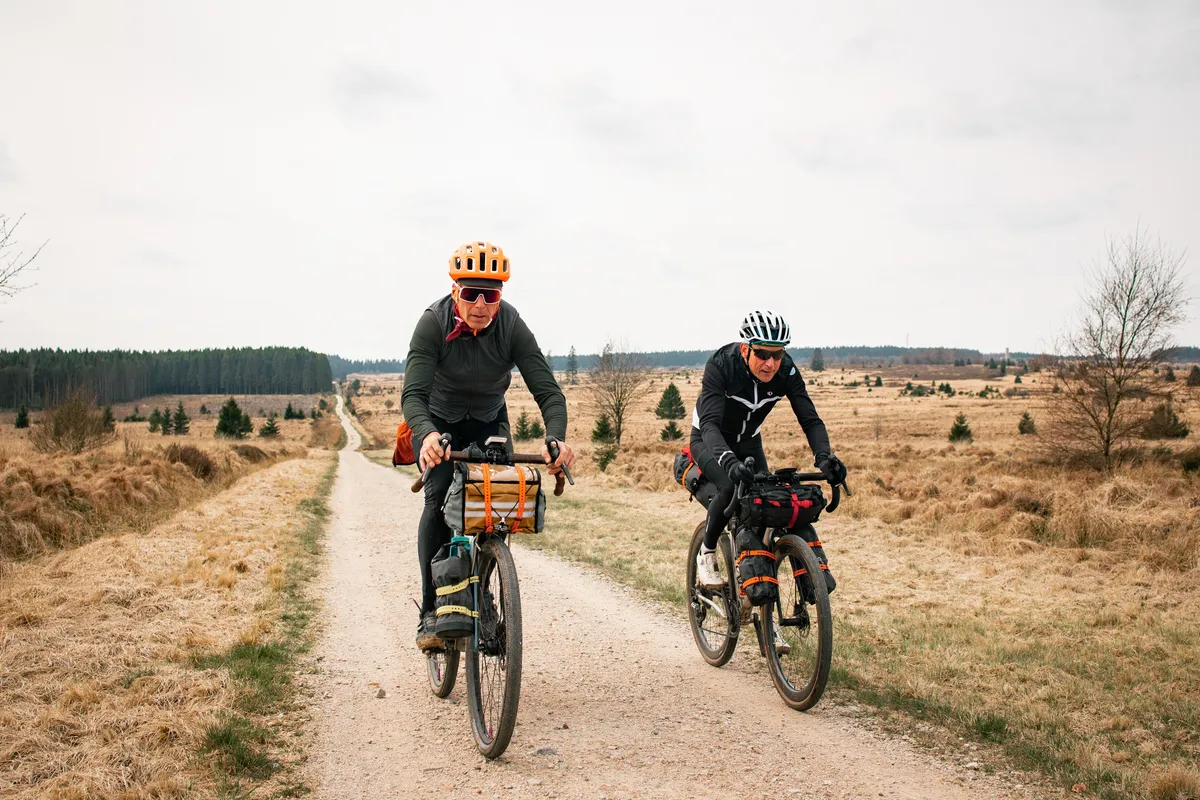 Twee bikepackers met bepakking op een zandpad over de heide