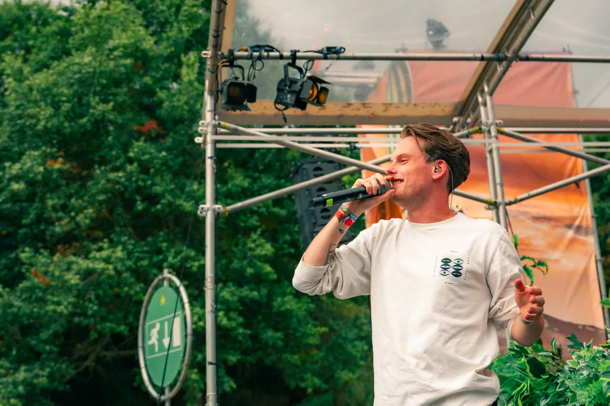 Dj drinkt iets op het podium tussen twee sets door