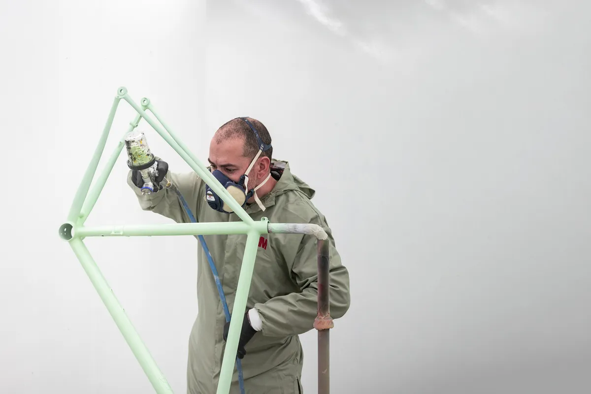 Framebouwer spuit een frame met beschermingsmasker op
