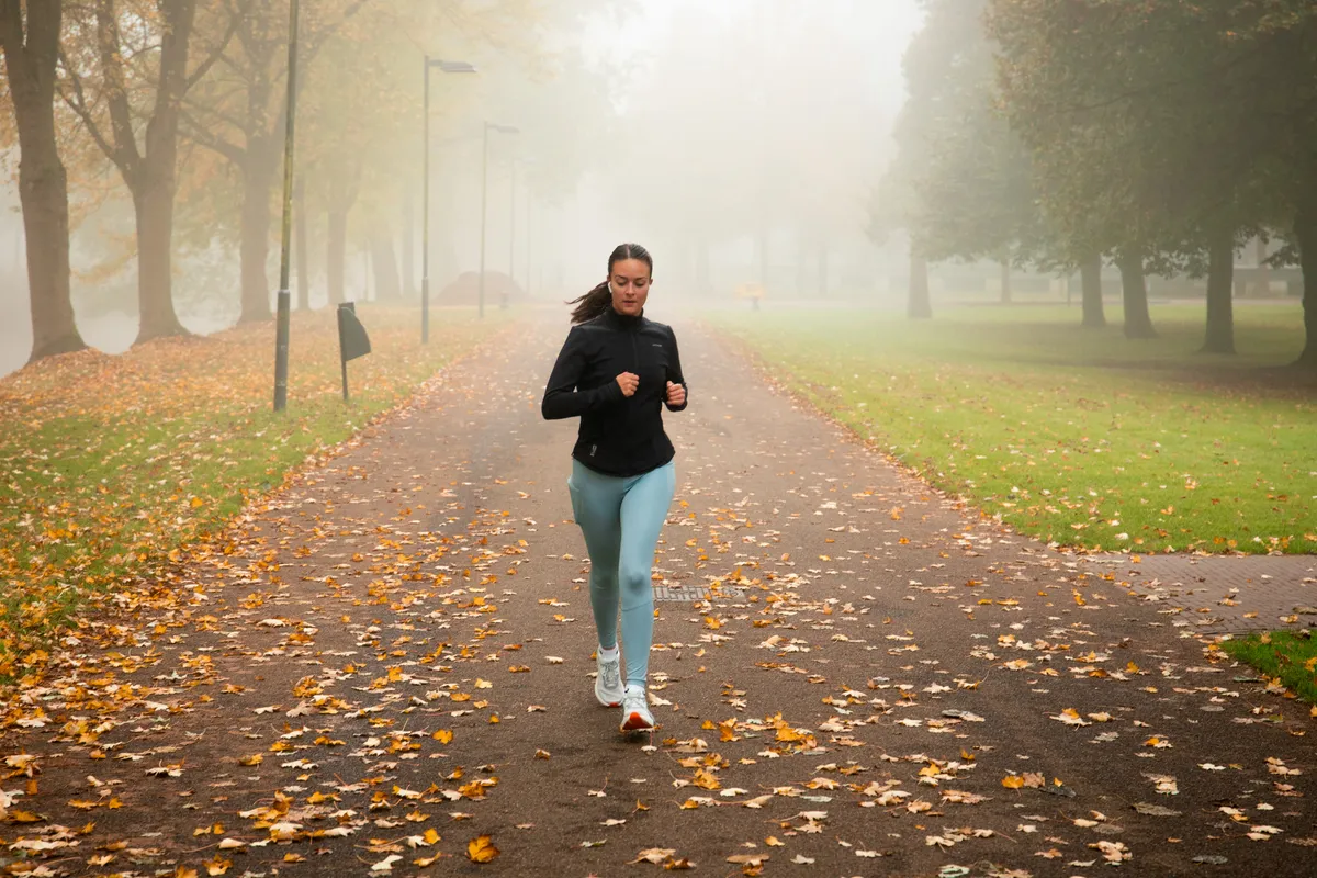Hardloopster in de ochtendmist in het park