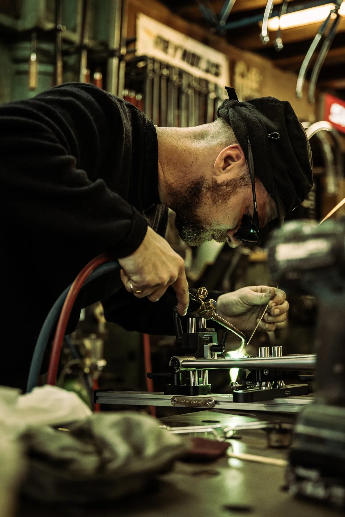 Framebouwer soldeert een stalen frame vast in de werkplaats