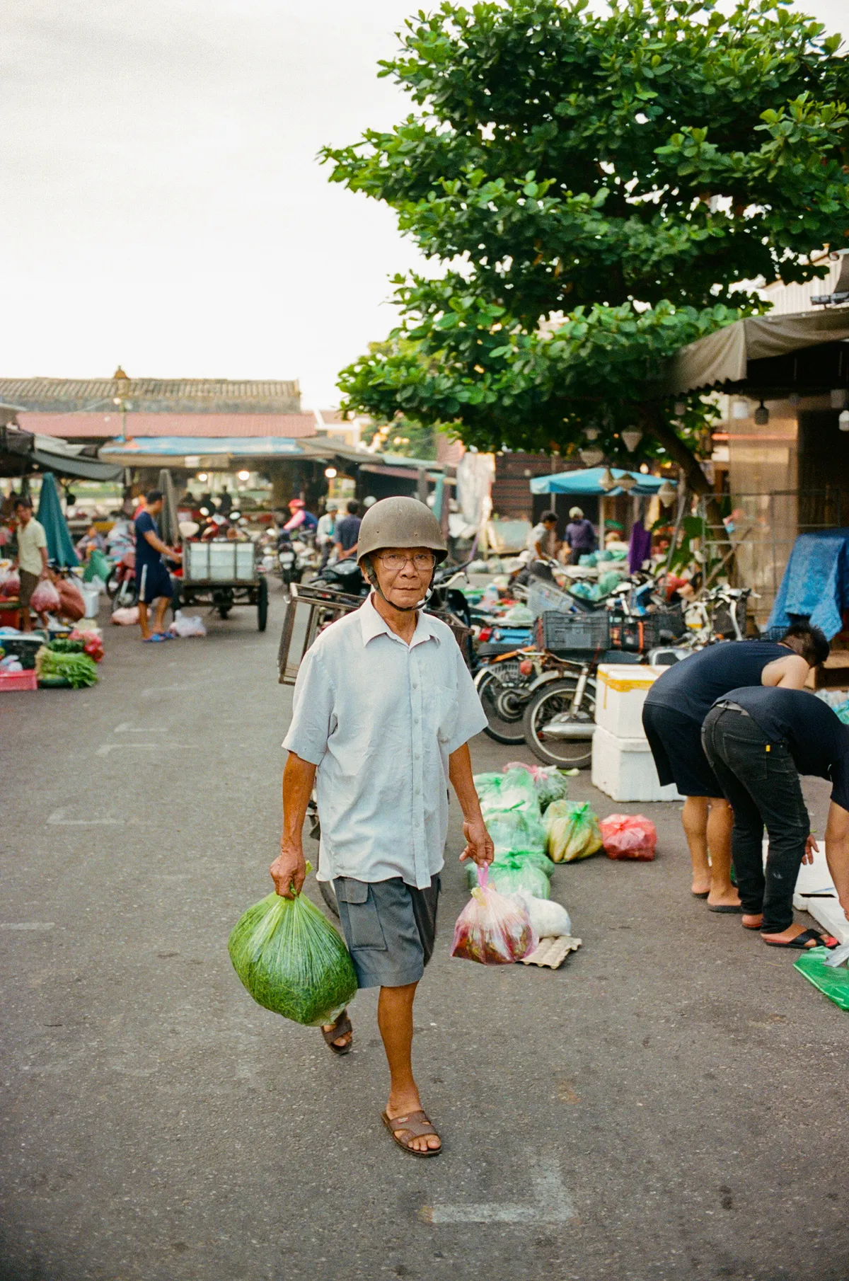 Man loopt met boodschappen over de markt, Vietnam