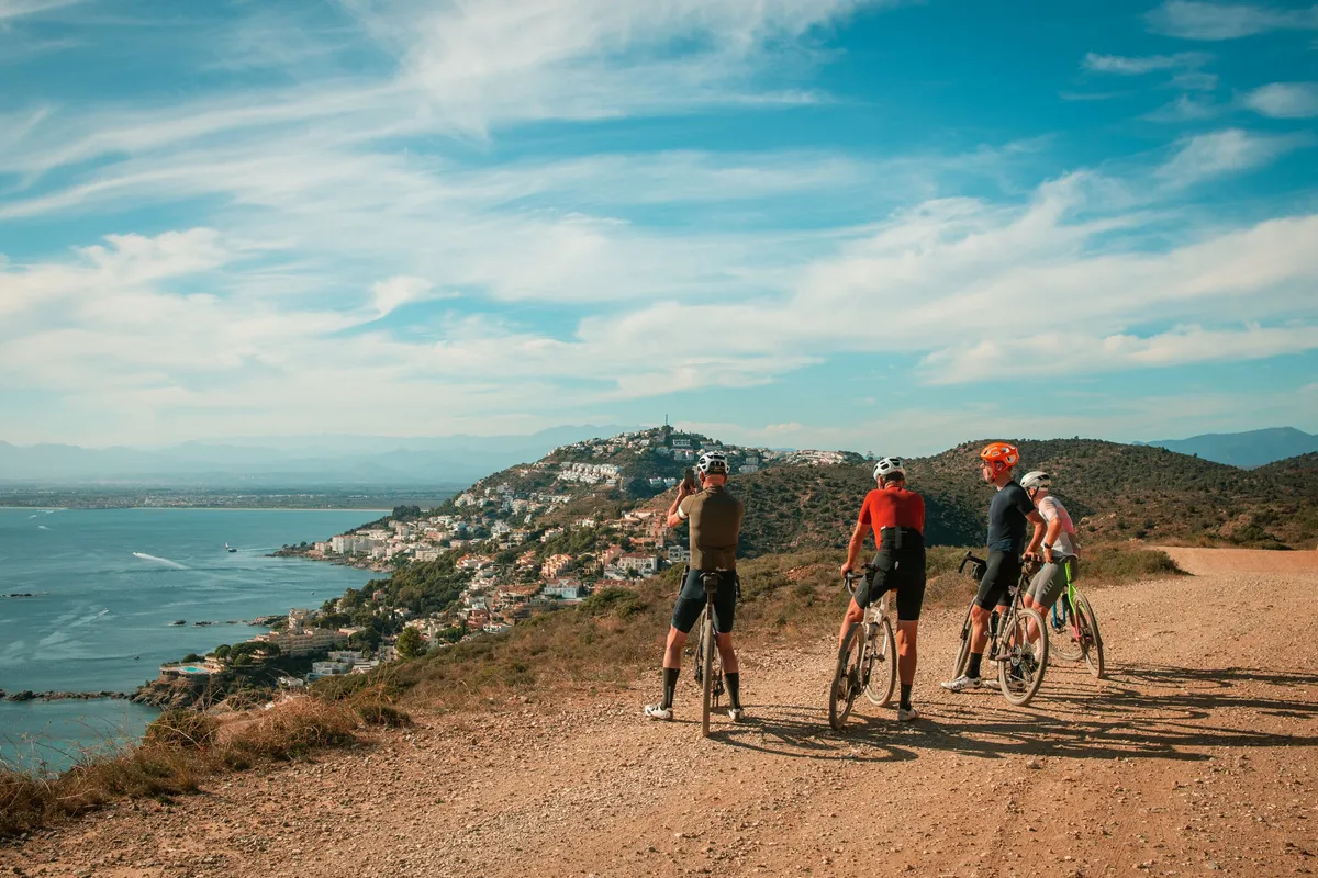 Drie renners op een pad boven de kust van Cap de Creus