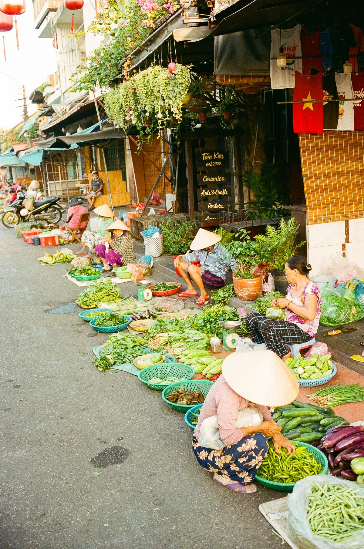 Groentemarkt op straat met verkoopsters op lage krukjes, Vietnam