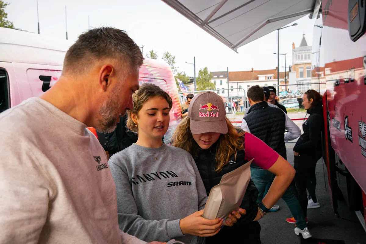 Il Magistrale-teamlid overhandigt koffie aan renners van Canyon//SRAM bij de ploegbus