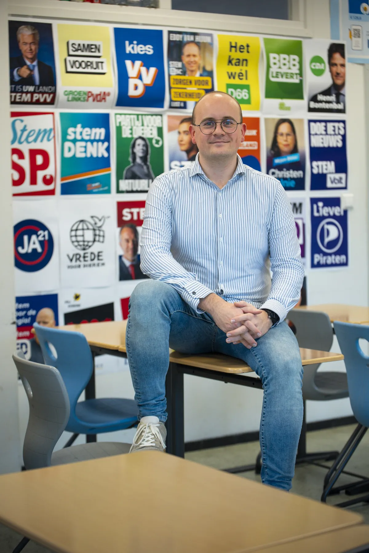 Portret van raadslid Koen Schouten in een klaslokaal vol verkiezingsposters